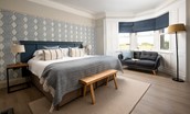 Caste View, Bamburgh - bedroom one located on the ground floor with a large bay window with sofa