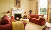 Fairnilee House - morning room with two 3-seater sofas and an open log fire