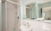 Honeystone House - bedroom four en-suite bathroom with shower and large mirror above the wash-hand basin