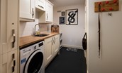 No. 6 - utility room leading to the rear garden with combi washer/dryer, basin and storage space