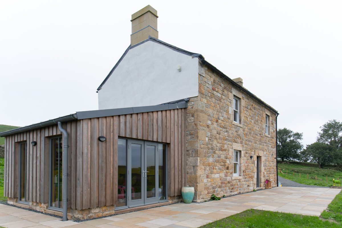 Lowtown Cottage - exterior with traditional Northumbrian brickwork and sun room extension