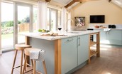 Shepherd's House - kitchen with island unit with granite work surface and doors leading out to raised patio to the front