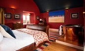 Lakeside Cottage - Edward - the bedroom is a deep sophisticated red with contrasting rich navy arched ceiling