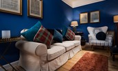The Hermitage - the sitting room has a large comfortable sofa with statement armchair