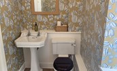 Wark Farmhouse - the cloakroom with statement wallpaper, WC and basin