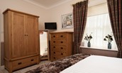 School View - bedroom one with wardrobe and chest of drawers