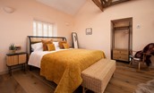 East Lodge Home Farm - bedroom one, with king size bed, bedside tables and chest of drawers with hanging rail