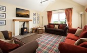 Hastings House - first floor sitting room with wood burning stove, three sofas and balconette offering countryside views