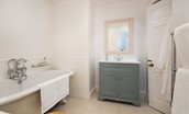 Honeystone House - Jack and Jill en suite of bedroom five featuring a deep roll top bath and vanity unit with basin