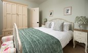 Kilham Cottage - bedroom one with king size bed, wardrobe with drawer below, bedside tables and lamps