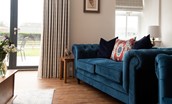 Mill Cottage, Brockmill Farm - sitting room with comfortable sofas in front of large glass doors providing lovely views of the garden