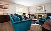 Westwood Cottage - sumptuous petrol-coloured sofa with matching armchair provide comfortable seating in front of the fire