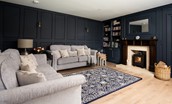West Mill Cottage - sitting room with midnight blue panelled walls and large plush sofas