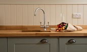 Trouthouse - solid wood worktop and undermounted sink with characterful wall panelling above
