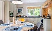 Culdoach Cottage - open plan dining area seating 4 guests with kitchen beyond