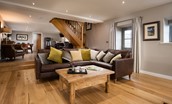 The Granary at Rothley East Shield - living room with 5-seater corner sofa and stairway to first floor