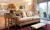Garden Cottage - a cosy spot with double sofa and doors leading onto the garden
