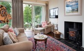 Brunton Burn - sitting room with wood-burning stove and door to the enclosed terrace