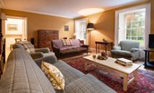 Church House - a large colourful vintage rug warms the stripped wooden floors in the sitting room