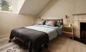 Trouthouse - bedroom three benefits from a double bed, original wooden flooring and decorative fireplace