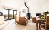 The Hemmel - open-plan living area with wood burning stove, sofas and dining area