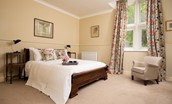 The Old School Hall - bedroom one with king size bed and armchair