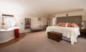 Anvil Cottage - spacious bedroom one with zip and link beds and roll top bath