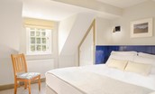 Culdoach Cottage - bedroom two with zip and link super king bed, built in wardrobe and chair