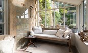 Honeystone House - relaxed bench seating in the airy garden room to enjoy views of the side lawned garden