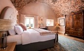 Lakeside Cottage - Alice - bedroom one boasts exposed brick arched ceilings and a tasteful blush pink colour scheme