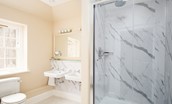 The Scott Apartment - the apartment's bathroom features a large walk-in shower with rainfall showerhead and a freestanding slipper bath