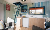 Berrington Beach Hut - kitchen with ladder to the upper sleeping area