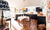 Long Byre - dining table with well-equipped kitchen beyond