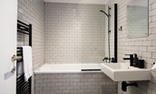 7 The Bay, Coldingham - family bathroom featuring a bath with shower over and stylish monochrome design