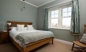 Sandsend - bedroom two with king size bed, wardrobe, chest of drawers and sea views from the window