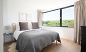 4 The Bay, Coldingham - bedroom one with king size bed and wrap-around window with views of rolling farmland