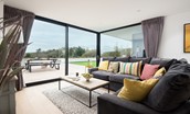 1 The Bay, Coldingham - full-length sliding doors and wrap-around window filling the sitting area with daylight