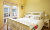 Friars Farm Cottage - bedroom one with king size bed and double doors leading into the conservatory