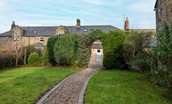 The Gallery - large lawned garden with gravelled patio through the archway