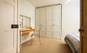 Trouthouse - bedroom one has full-height built-in wardrobes providing ample storage and a neat dressing table
