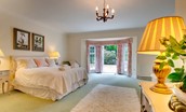 The Eslington Lodge - bedroom one with double bed and French doors to garden