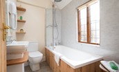 The Woodworker's Cottage - family bathroom featuring a bath with shower over