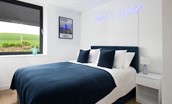 2 The Bay, Coldingham - bedroom one features a king size bed with bespoke neon sign mounted above
