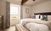 Brockmill Farmhouse - bedroom six with zip and link beds, exposed beams and large south-facing windows with original shutters