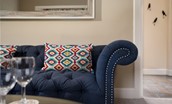Birch Cottage - vibrant cushions pop against the inky blue Chesterfield sofa
