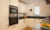 Bamburgh Five - kitchen with electric oven and hob, combination microwave, large fridge/freezer, and dishwasher