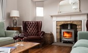 Sandsend - sitting room with two large sofas and wing back armchairs for guests to settle in front of the cosy log burner