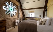 Lindisfarne View - bedroom one with cast iron king size bed and stained glass feature window