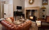 The Lodge, Lesbury - small chesterfield sofa and a wood burning stove