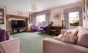 Fell End - sitting room with 64 inch smart TV set in large stone inglenook and designated workspace